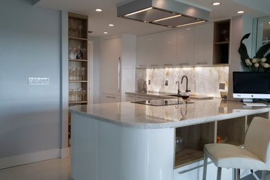 Small trendy l-shaped porcelain tile and white floor eat-in kitchen photo in Miami with an undermount sink, flat-panel cabinets, white cabinets, quartzite countertops, beige backsplash, stainless steel appliances, an island and beige countertops