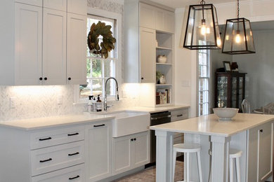 Eat-in kitchen - mid-sized transitional galley dark wood floor and brown floor eat-in kitchen idea in Miami with a farmhouse sink, shaker cabinets, white cabinets, quartz countertops, white backsplash, marble backsplash, stainless steel appliances, an island and white countertops