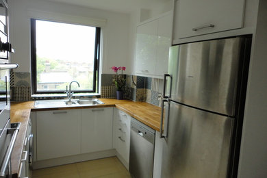This is an example of a small contemporary u-shaped enclosed kitchen in London with no island.