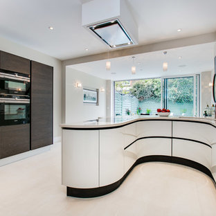 Contemporary u-shaped kitchen in Oxfordshire with a submerged sink, flat-panel cabinets, white cabinets, mirror splashback, white floors and white worktops.