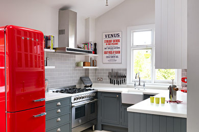 Inspiration for a small classic u-shaped enclosed kitchen in London with a belfast sink, shaker cabinets, grey cabinets, grey splashback, metro tiled splashback, no island, composite countertops, stainless steel appliances, ceramic flooring and beige floors.