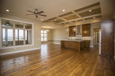 Example of a mid-sized mountain style l-shaped medium tone wood floor and brown floor open concept kitchen design in Other with an undermount sink, recessed-panel cabinets, medium tone wood cabinets, quartz countertops, white backsplash, subway tile backsplash, stainless steel appliances and an island