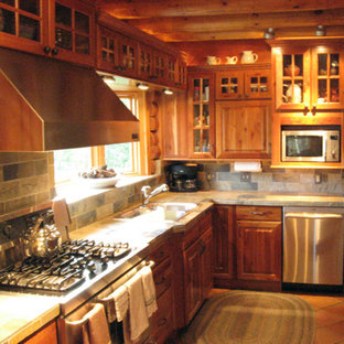 Photo of a mid-sized country l-shaped separate kitchen in Austin with a double-bowl sink, raised-panel cabinets, dark wood cabinets, tile benchtops, multi-coloured splashback, slate splashback, stainless steel appliances, terra-cotta floors, no island, orange floor and multi-coloured benchtop.