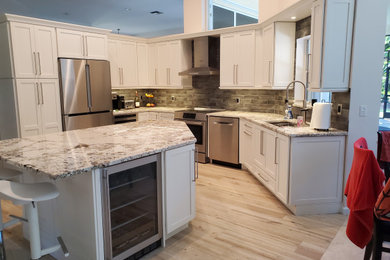 Mid-sized transitional porcelain tile and beige floor open concept kitchen photo in Miami with an undermount sink, shaker cabinets, white cabinets, granite countertops, gray backsplash, subway tile backsplash, stainless steel appliances, an island and multicolored countertops