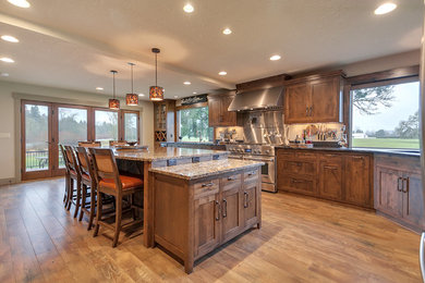 Inspiration for a large transitional l-shaped light wood floor eat-in kitchen remodel in Portland with an undermount sink, shaker cabinets, medium tone wood cabinets, marble countertops, gray backsplash, stone slab backsplash, stainless steel appliances and an island