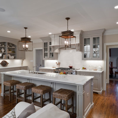 Inspiration for a timeless u-shaped open concept kitchen remodel in Charlotte with recessed-panel cabinets, gray cabinets, white backsplash, paneled appliances and white countertops