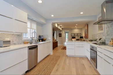 Exempel på ett stort modernt kök med öppen planlösning, med en undermonterad diskho, släta luckor, vita skåp, bänkskiva i kvartsit, grönt stänkskydd, stänkskydd i marmor, rostfria vitvaror, ljust trägolv, en halv köksö och beiget golv