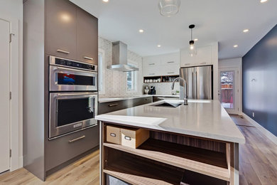 Imagen de cocina contemporánea de tamaño medio con armarios con paneles lisos, puertas de armario de madera en tonos medios, salpicadero blanco, suelo de madera clara, una isla, suelo marrón, electrodomésticos de acero inoxidable, fregadero de doble seno y encimeras blancas