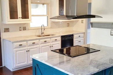 Transitional galley medium tone wood floor and brown floor open concept kitchen photo in Atlanta with an undermount sink, raised-panel cabinets, white cabinets, marble countertops, white backsplash, subway tile backsplash, stainless steel appliances and an island