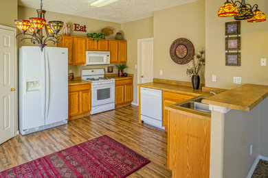 Example of a southwest medium tone wood floor kitchen design in Albuquerque with recessed-panel cabinets and medium tone wood cabinets