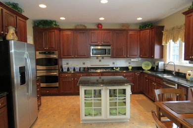 Immagine di una cucina chic di medie dimensioni con ante in legno scuro e elettrodomestici in acciaio inossidabile