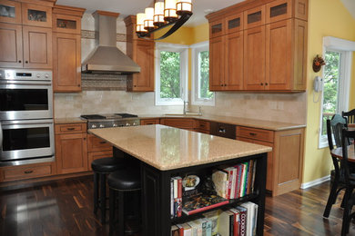 Example of a large minimalist u-shaped dark wood floor eat-in kitchen design in DC Metro with light wood cabinets, quartz countertops, stainless steel appliances and an island