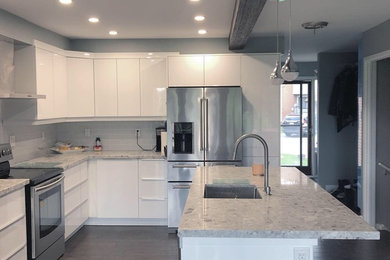 Mid-sized minimalist l-shaped eat-in kitchen photo in Toronto with flat-panel cabinets, white cabinets, marble countertops, gray backsplash, an island and gray countertops