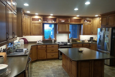 Large farmhouse laminate floor eat-in kitchen photo in Other with an integrated sink, raised-panel cabinets and an island