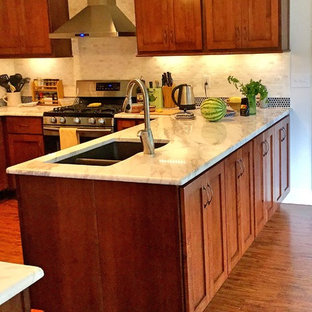This is an example of a mid-sized contemporary u-shaped eat-in kitchen in Atlanta with a double-bowl sink, shaker cabinets, dark wood cabinets, granite benchtops, white splashback, ceramic splashback, stainless steel appliances, medium hardwood floors and a peninsula.