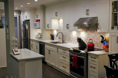 Design ideas for a medium sized traditional galley kitchen/diner in Vancouver with a submerged sink, beige splashback, stone tiled splashback, stainless steel appliances, dark hardwood flooring, brown floors, shaker cabinets, white cabinets, composite countertops, an island and white worktops.