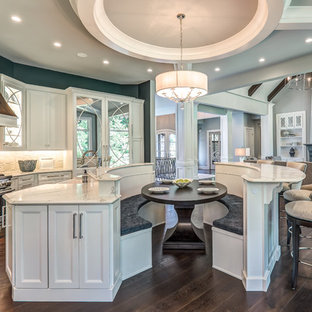 Inspiration for a large timeless single-wall dark wood floor and brown floor open concept kitchen remodel in Columbus with a farmhouse sink, flat-panel cabinets, white cabinets, white backsplash, paneled appliances and two islands