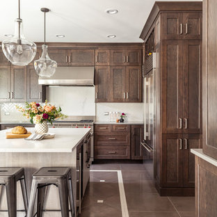 This is an example of a mid-sized transitional u-shaped eat-in kitchen in Chicago with an undermount sink, shaker cabinets, dark wood cabinets, quartz benchtops, ceramic splashback, stainless steel appliances, porcelain floors, with island, multi-coloured floor, white benchtop and beige splashback.