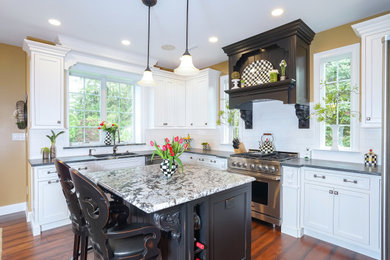 Example of a large classic u-shaped medium tone wood floor and brown floor eat-in kitchen design in Philadelphia with a double-bowl sink, beaded inset cabinets, white cabinets, quartzite countertops, white backsplash, marble backsplash, stainless steel appliances, an island and black countertops