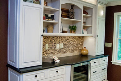 Photo of a large traditional l-shaped enclosed kitchen in Other with a single-bowl sink, raised-panel cabinets, white cabinets, granite worktops, multi-coloured splashback, glass tiled splashback, stainless steel appliances, porcelain flooring, an island, beige floors and beige worktops.