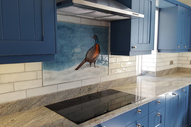 Design ideas for a large modern kitchen in Hampshire with blue splashback, glass tiled splashback and integrated appliances.