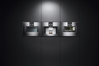 Foto de cocina comedor lineal moderna con armarios con paneles lisos, puertas de armario grises y electrodomésticos de acero inoxidable