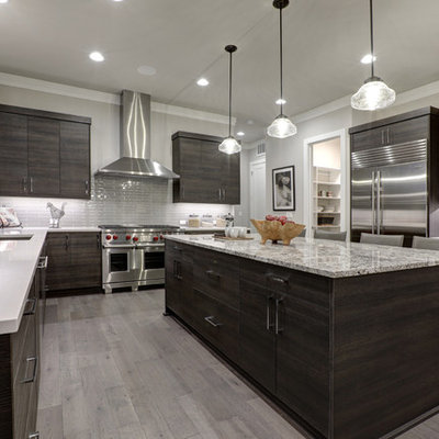 Example of a large minimalist u-shaped porcelain tile and gray floor eat-in kitchen design in Jacksonville with an undermount sink, stainless steel appliances, an island, flat-panel cabinets, dark wood cabinets, quartzite countertops, gray backsplash, subway tile backsplash and multicolored countertops