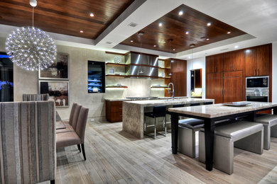 Eat-in kitchen - contemporary laminate floor eat-in kitchen idea in Orange County with flat-panel cabinets, dark wood cabinets and paneled appliances