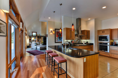Mittelgroße Moderne Wohnküche in L-Form mit Unterbauwaschbecken, Schrankfronten im Shaker-Stil, hellen Holzschränken, Küchengeräten aus Edelstahl, hellem Holzboden, Halbinsel, bunter Rückwand, Rückwand aus Keramikfliesen und beigem Boden in Seattle