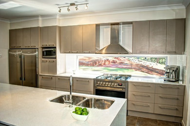 Foto på ett stort funkis kök, med en undermonterad diskho, rostfria vitvaror, bänkskiva i kvarts, klinkergolv i porslin och en köksö