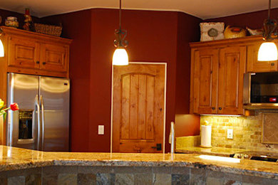 フェニックスにあるおしゃれなキッチン (中間色木目調キャビネット、ベージュキッチンパネル、シルバーの調理設備) の写真