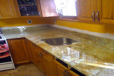 Example of a classic kitchen design in Baltimore with medium tone wood cabinets, granite countertops and white appliances