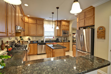 Example of a large u-shaped ceramic tile enclosed kitchen design in Salt Lake City with raised-panel cabinets, medium tone wood cabinets, granite countertops, stainless steel appliances and an island