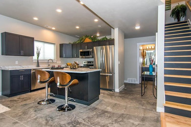 Eat-in kitchen - mid-sized concrete floor eat-in kitchen idea in Salt Lake City with beaded inset cabinets, black cabinets and an island