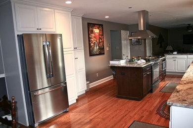 Kitchen pantry - large transitional u-shaped medium tone wood floor, brown floor and vaulted ceiling kitchen pantry idea in Philadelphia with shaker cabinets, white cabinets, granite countertops, stainless steel appliances, an island, multicolored countertops, black backsplash, matchstick tile backsplash and an undermount sink