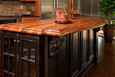 Mid-sized dark wood floor open concept kitchen photo in Raleigh with recessed-panel cabinets, dark wood cabinets, wood countertops, multicolored backsplash, matchstick tile backsplash, stainless steel appliances and an island