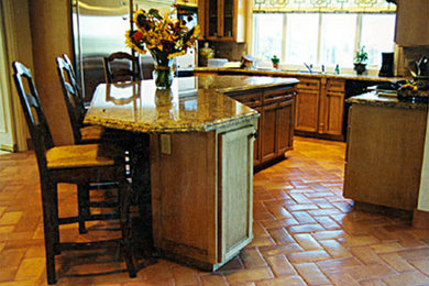 Foto de cocina clásica con puertas de armario de madera oscura, encimera de granito, electrodomésticos de acero inoxidable y una isla