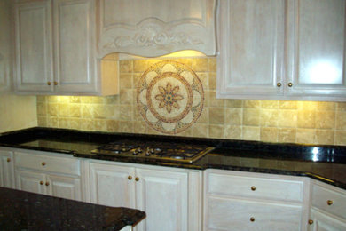 Mid-sized l-shaped kitchen photo in Other with raised-panel cabinets, beige cabinets, black appliances and two islands
