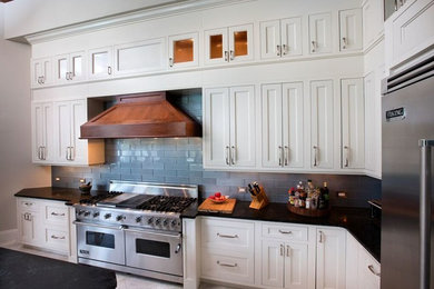 マイアミにある広いトラディショナルスタイルのおしゃれなキッチン (シェーカースタイル扉のキャビネット、白いキャビネット、ソープストーンカウンター、グレーのキッチンパネル、シルバーの調理設備、サブウェイタイルのキッチンパネル、ライムストーンの床) の写真