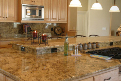 Example of a large l-shaped eat-in kitchen design in Jacksonville with raised-panel cabinets, light wood cabinets, granite countertops, beige backsplash, stone slab backsplash, stainless steel appliances and an island