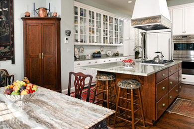 Example of a mid-sized classic u-shaped dark wood floor eat-in kitchen design in DC Metro with a double-bowl sink, raised-panel cabinets, white cabinets, soapstone countertops, gray backsplash, stone slab backsplash, stainless steel appliances and an island