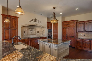 Large arts and crafts u-shaped ceramic tile enclosed kitchen photo in Albuquerque with a double-bowl sink, medium tone wood cabinets, multicolored backsplash, stainless steel appliances, an island, raised-panel cabinets, marble countertops and cement tile backsplash