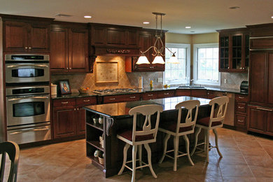 Eat-in kitchen - mid-sized traditional l-shaped ceramic tile and beige floor eat-in kitchen idea in Other with a double-bowl sink, raised-panel cabinets, granite countertops, beige backsplash, ceramic backsplash, stainless steel appliances, an island and dark wood cabinets