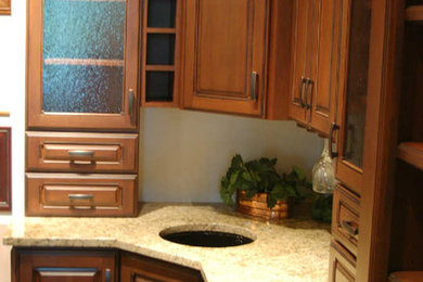 Imagen de cocina tradicional renovada con puertas de armario de madera en tonos medios y encimera de granito