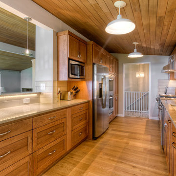 Galley Kitchen Featuring Stainless Steel Appliances, Subway Tile Backsplash, and