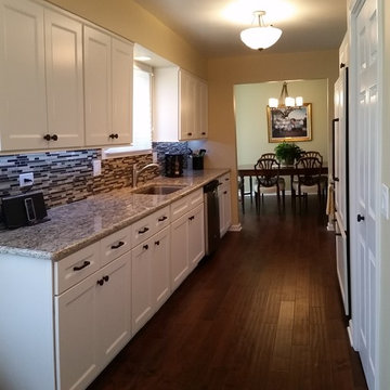 Galley Kitchen with Refaced White Cabinetry and New Wood Flooring