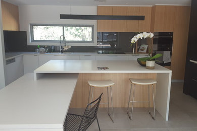 Große Küche mit Quarzwerkstein-Arbeitsplatte und Glasrückwand in Sydney