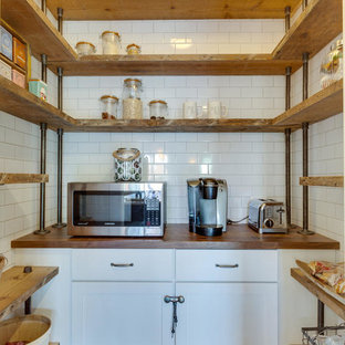 Foto di una cucina country di medie dimensioni con ante bianche, top in legno, paraspruzzi bianco, elettrodomestici in acciaio inossidabile, pavimento in legno massello medio, paraspruzzi con piastrelle diamantate, lavello sottopiano, ante in stile shaker e isola