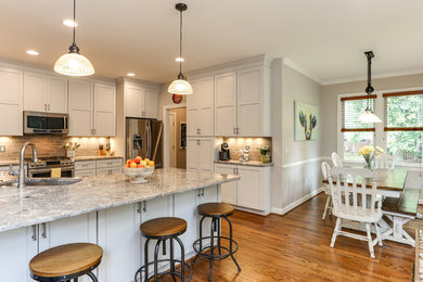 Eat-in kitchen - large farmhouse u-shaped medium tone wood floor and brown floor eat-in kitchen idea in Raleigh with an undermount sink, shaker cabinets, gray cabinets, granite countertops, gray backsplash, ceramic backsplash and stainless steel appliances