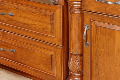 Imagen de cocina clásica con puertas de armario de madera oscura, encimera de cuarzo compacto, salpicadero beige y salpicadero de azulejos de piedra